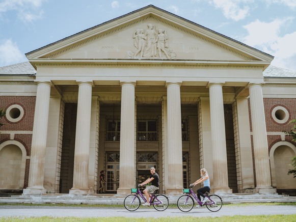 A couple riding bikes in front of the Roosevelt Baths & Spa